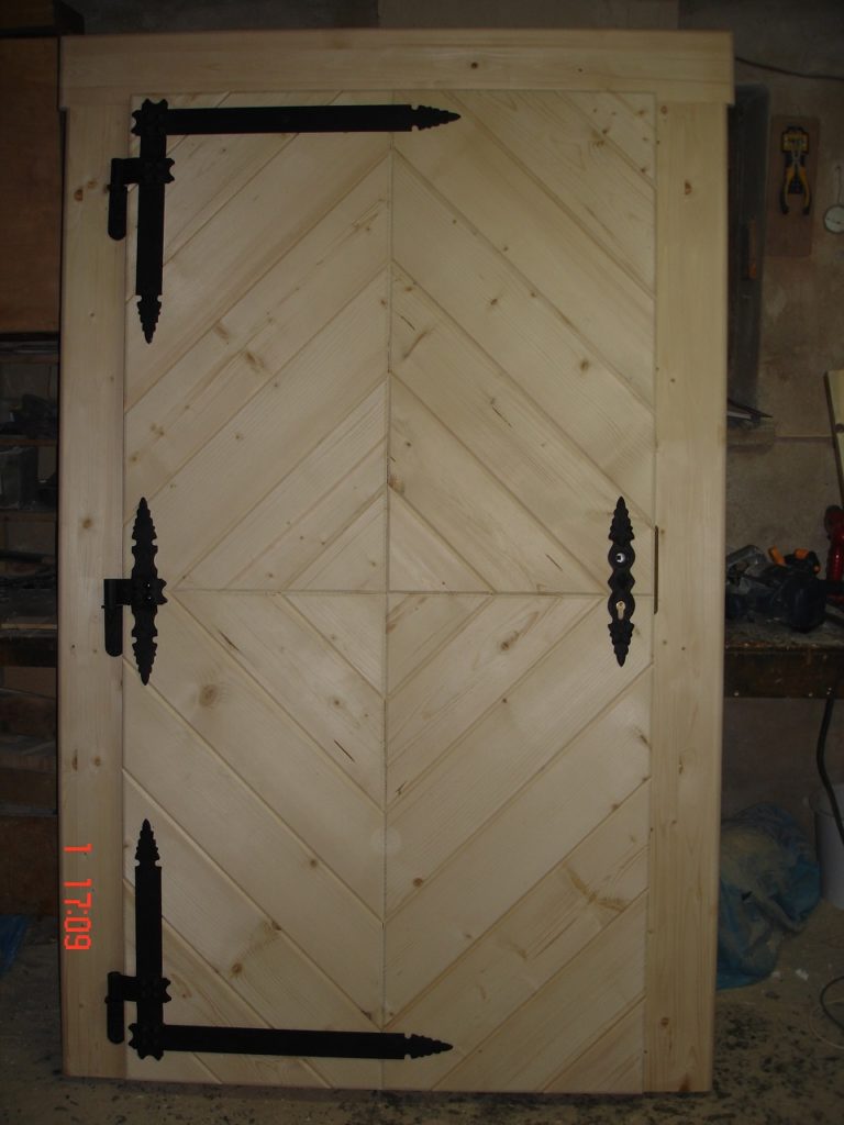drewniane drzwi wejsciowe z czarnymi okuciami
