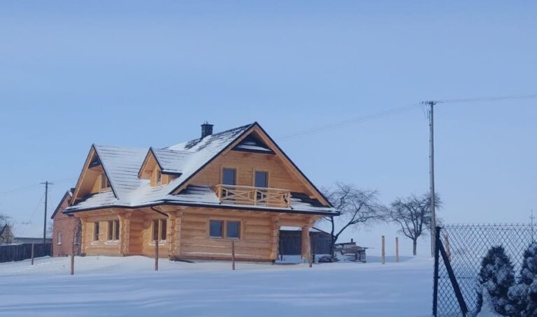dom drewniany w sniegu-polokragle bale