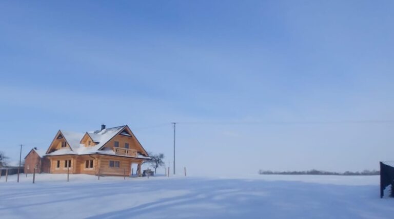 dom drewniany w sniegu-polokragle bale